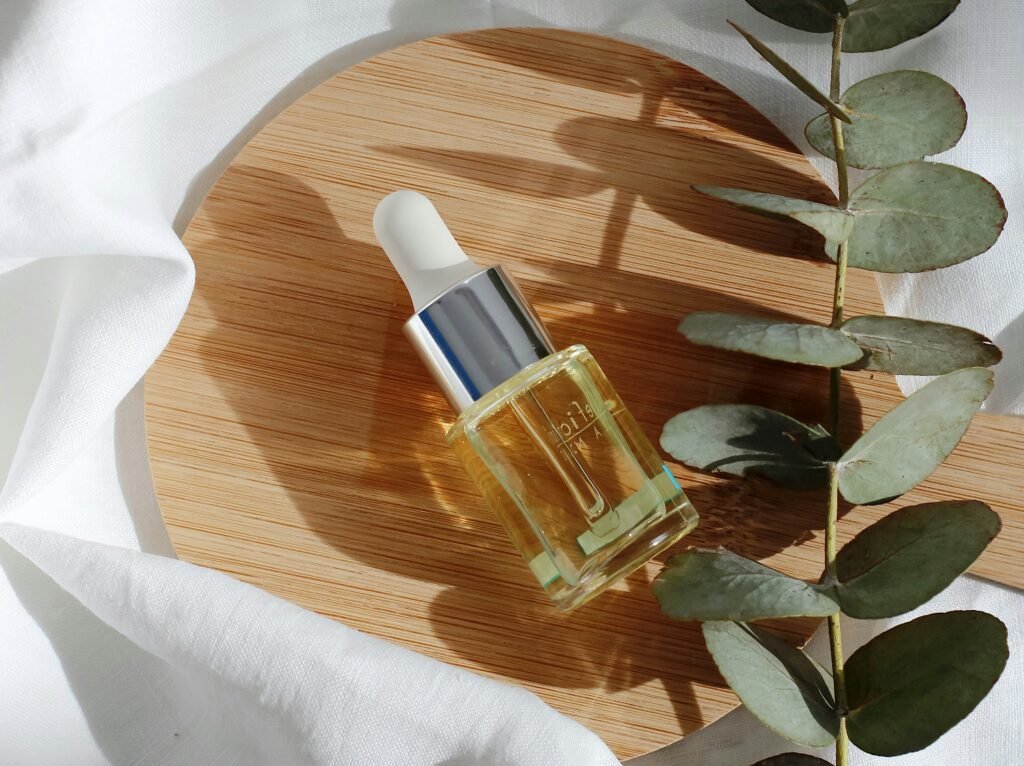 Gdzie kryje się laktoza, poza dietą_ 2 obszary, na które musisz szczególnie uważać Butelka z pipetą wypełniona olejkiem kosmetycznym, leżąca na okrągłej drewnianej desce, obok gałązki eukaliptusa, w naturalnym świetle.