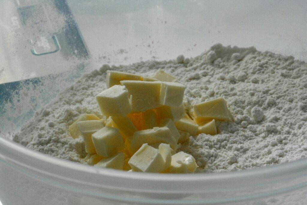 Masło w kostkach dodane do mąki – składnik ciasta, który można zastąpić zamiennikami